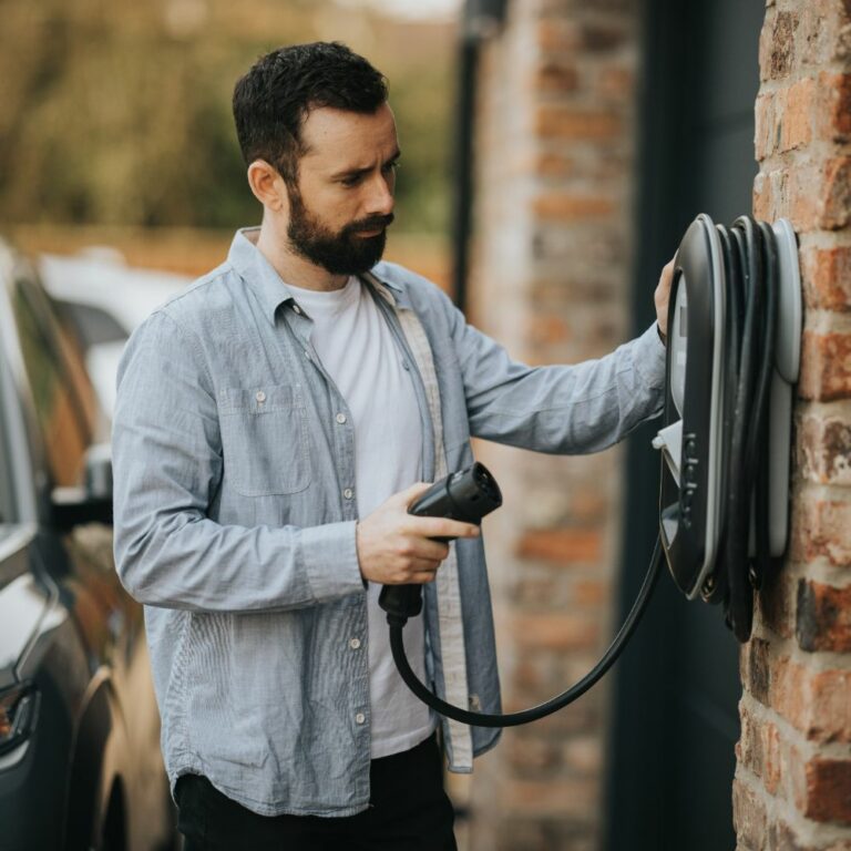 A zappi EV charger being plugged in by a man